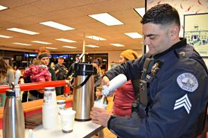 St. Helens police officer puts whipped cream on cup of cocoa 